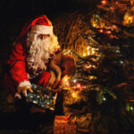 Der Weihnachtsmann legt die Geschenke unter den Baum